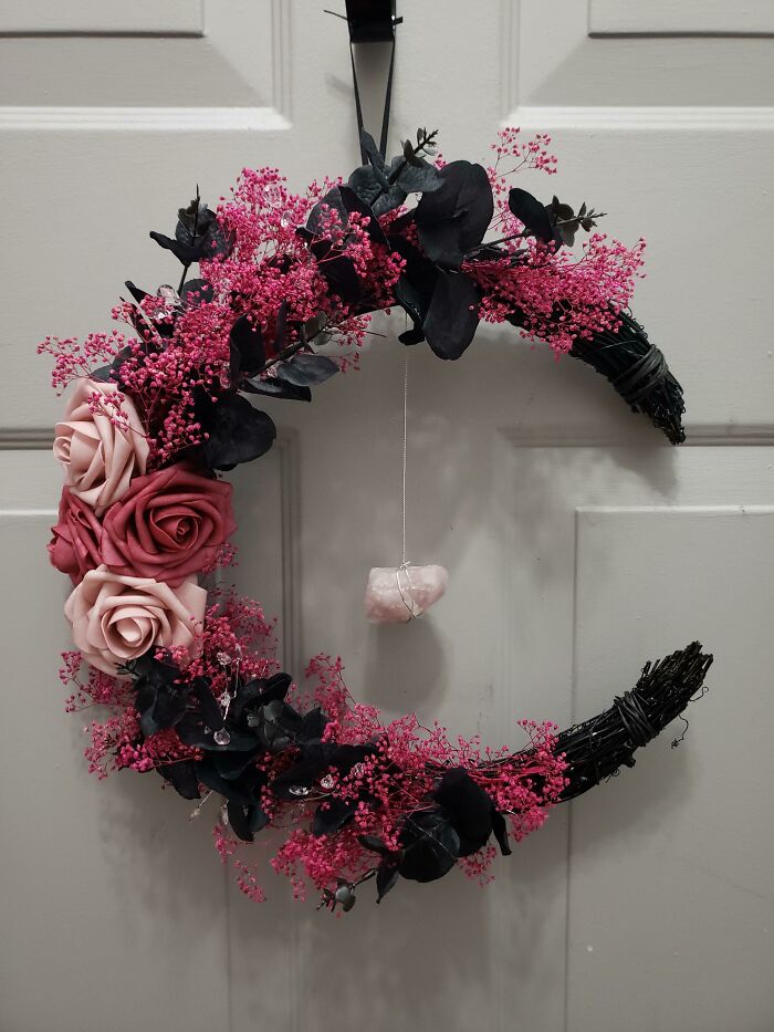 Decorative pink and black floral wreath on a door for home decoration ideas.