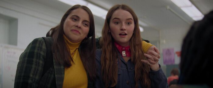 Two best friends smiling in a classroom, symbolizing iconic friendship.