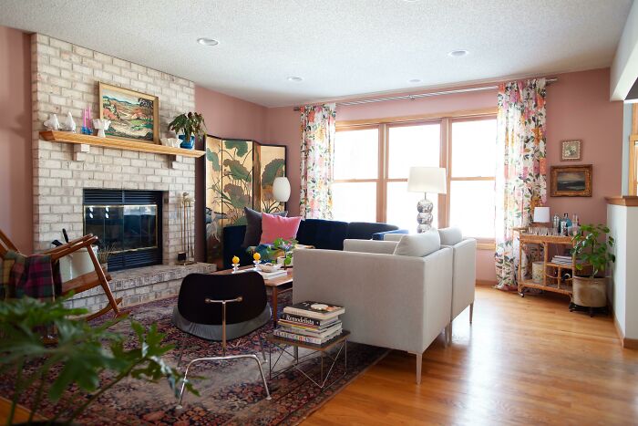 Cozy living room with floral curtains, fireplace, and eclectic home decoration accents.