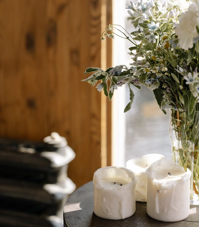 Candles and a floral arrangement on a wooden table, providing creative inspiration for home decoration ideas.