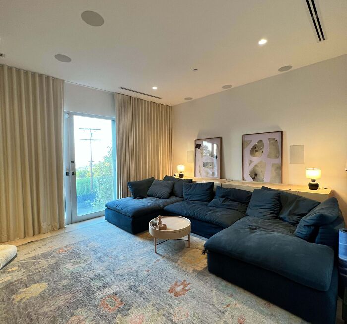 Stylish living room with blue sectional sofa and abstract art, showcasing home decoration ideas.