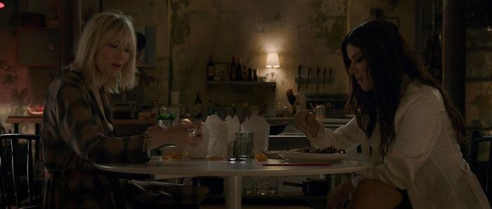 Two women sitting at a table in a dimly lit room, enjoying a meal together, showcasing iconic best friend duos.