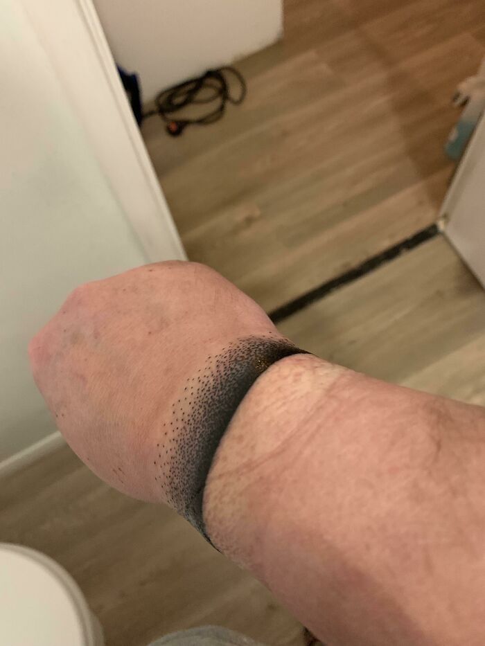 Dark band wrist tattoo on light skin, showcasing unique dot gradient design.