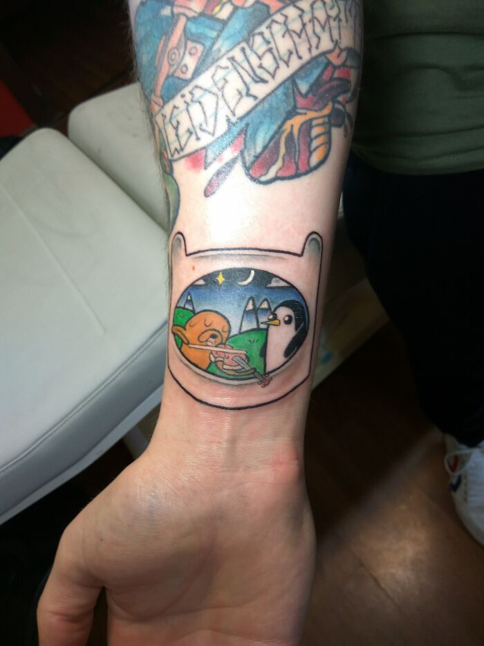 Colorful wrist tattoo design featuring a cartoon motif, showcasing unique and creative ink art on the skin.