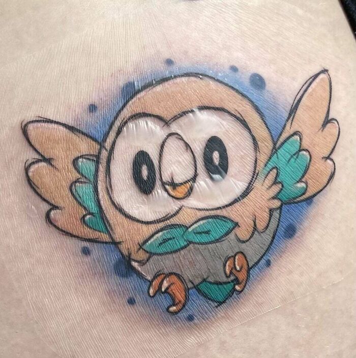 Cute cartoon owl tattoo design with vibrant colors, a whimsical choice for animal tattoo inspiration.