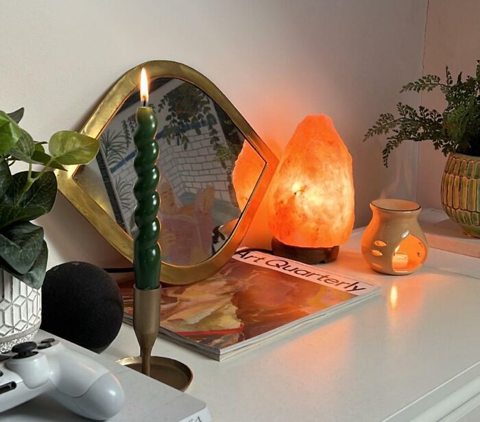 Creative decoration inspiration with candle, mirror, and salt lamp on a stylish shelf.