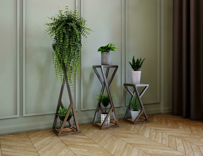 Stylish home decoration with geometric plant stands and green houseplants in a modern room setting.