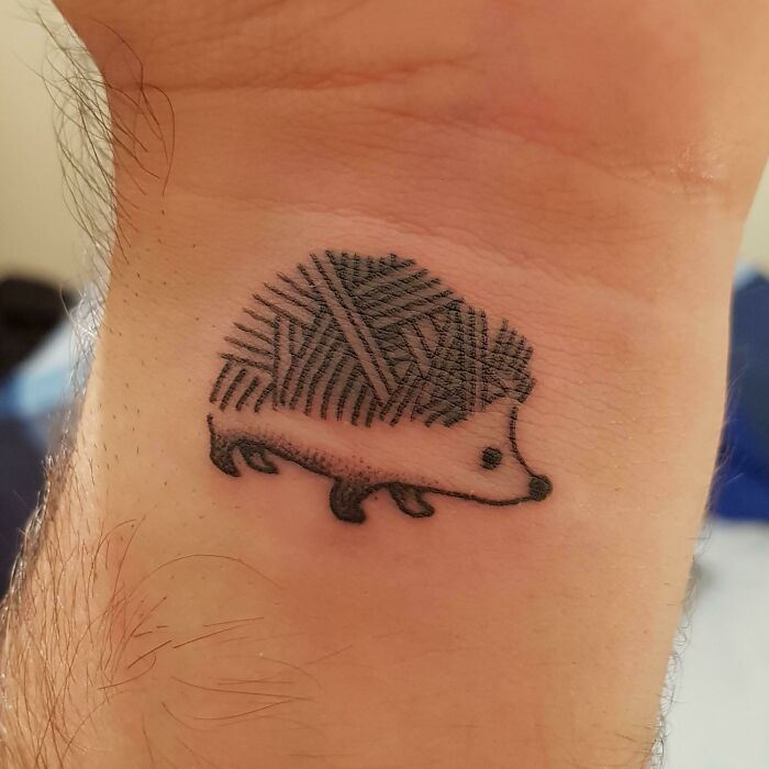 Hedgehog tattoo on wrist, showcasing bold statement ink art.