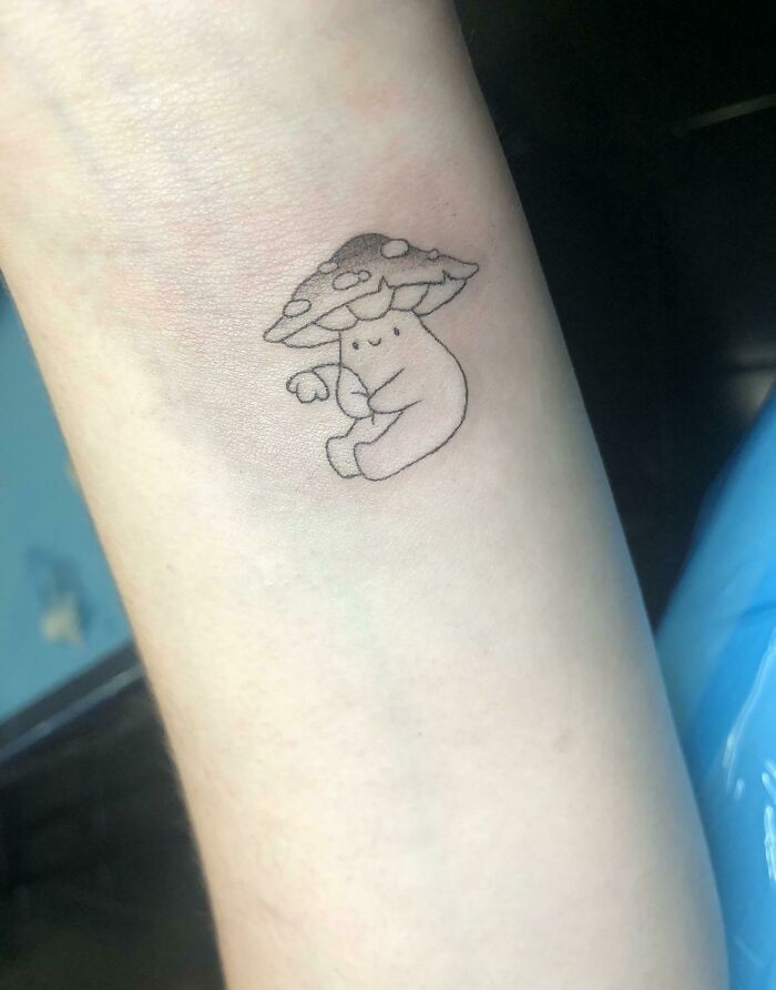 Cute wrist tattoo of a character with a mushroom hat, adding a whimsical statement.