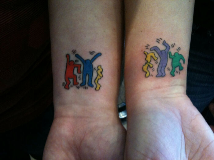 Colorful wrist tattoos featuring abstract dancing figures.