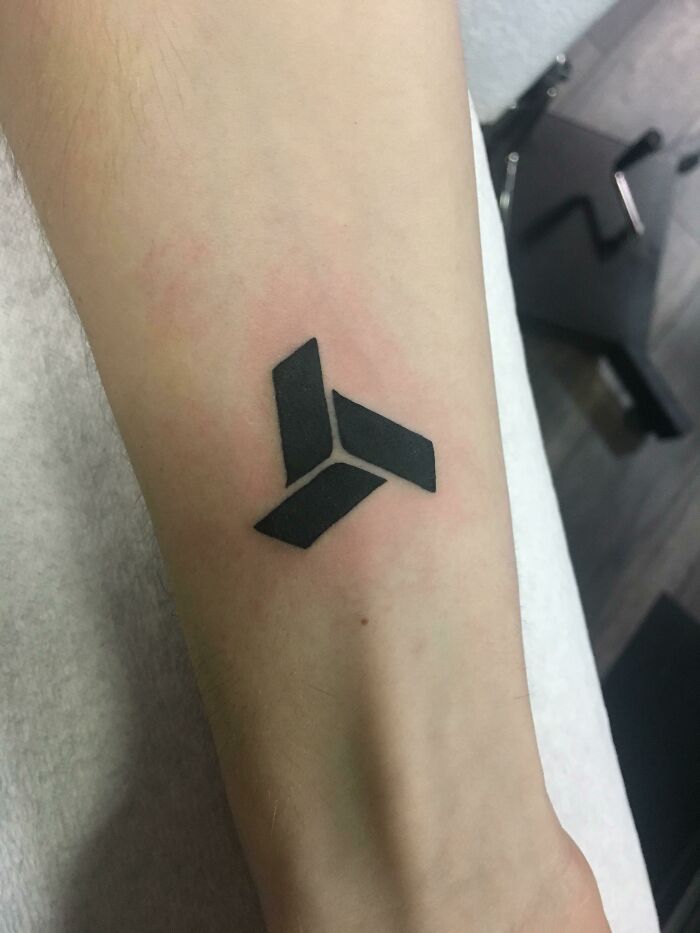 Geometric wrist tattoo design showcasing bold, black shapes.