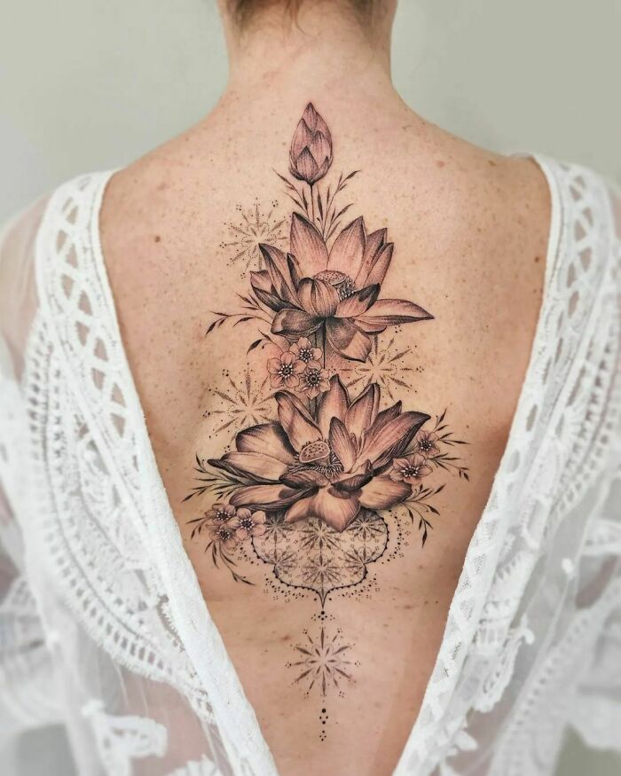 A beautiful spine tattoo featuring intricate floral designs on a woman's back.