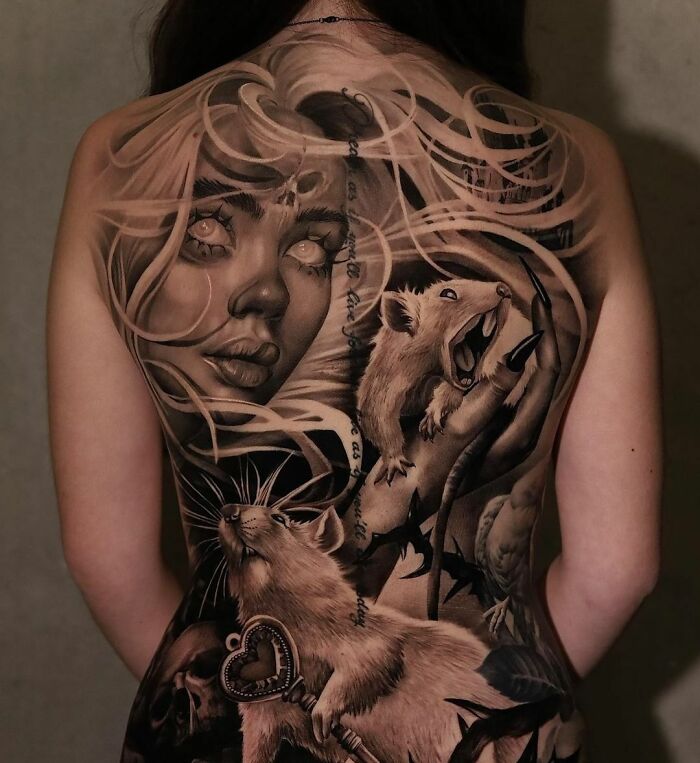 Realistic tattoo art on back featuring a woman’s face and detailed creatures, showcasing flawless tattoo realism.