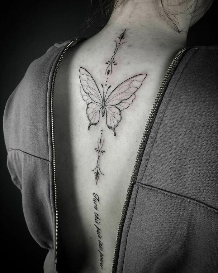 Butterfly spine tattoo design on a person's back, showcasing elegant tattoo ideas.