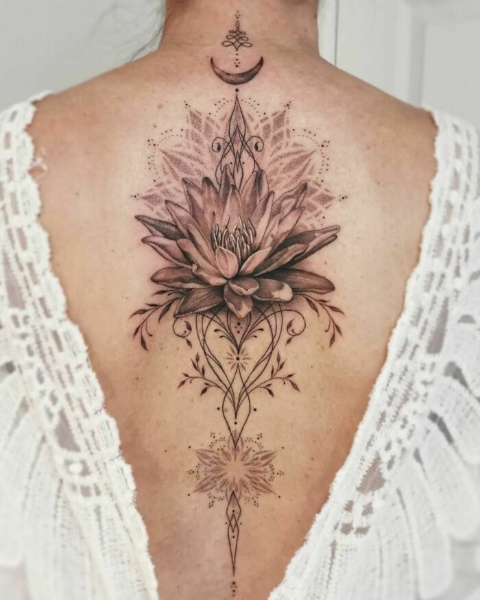 Elegant spine tattoo design featuring a detailed floral and geometric pattern on the back of a person.