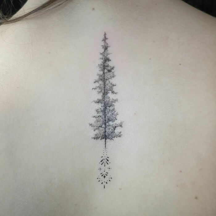 Intricate tree design as a spine tattoo, showcasing detailed artistry on skin.