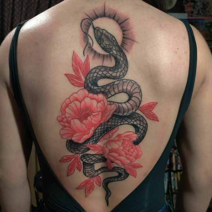 Back with beautiful spine tattoo of a snake and red flowers.