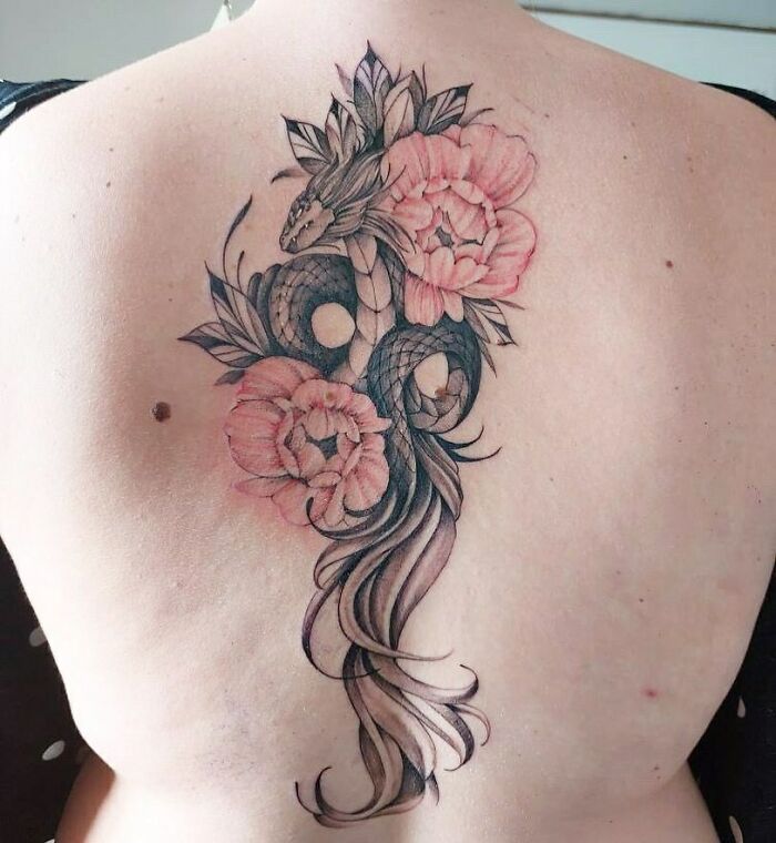 Beautiful spine tattoo featuring a snake entwined with pink flowers and leaves.