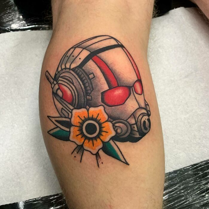 Colorful Marvel tattoo featuring Ant-Man helmet with a yellow flower.