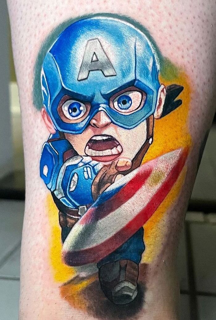 Colorful Marvel tattoo of a chibi-style superhero Little Captain America with a blue helmet and shield, on a person's skin.