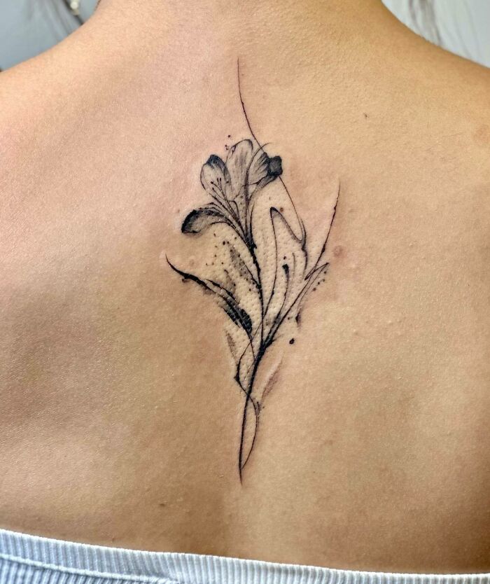 Elegant floral spine tattoo design on a person's back.