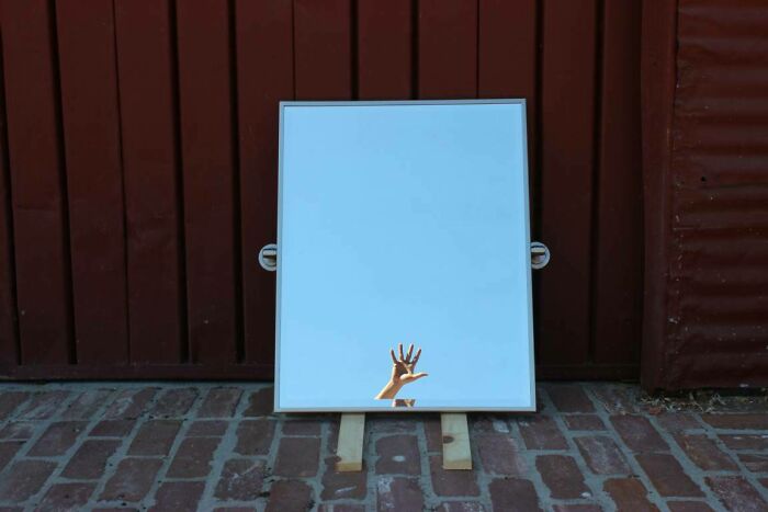 Hand in a mirror reflection outside 