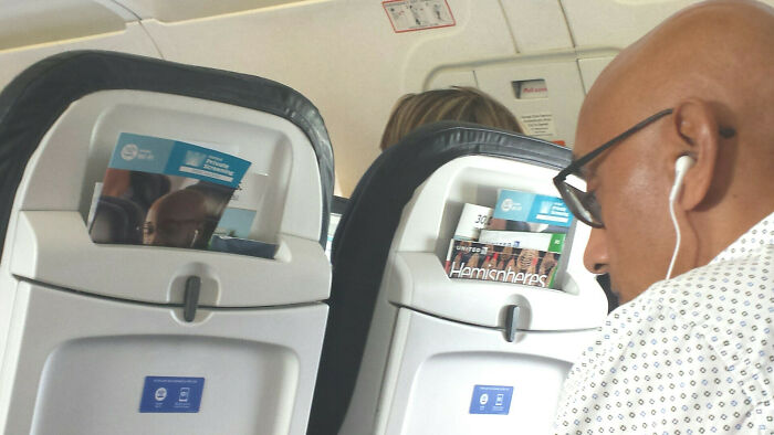Man with headphones sitting in an airplane 