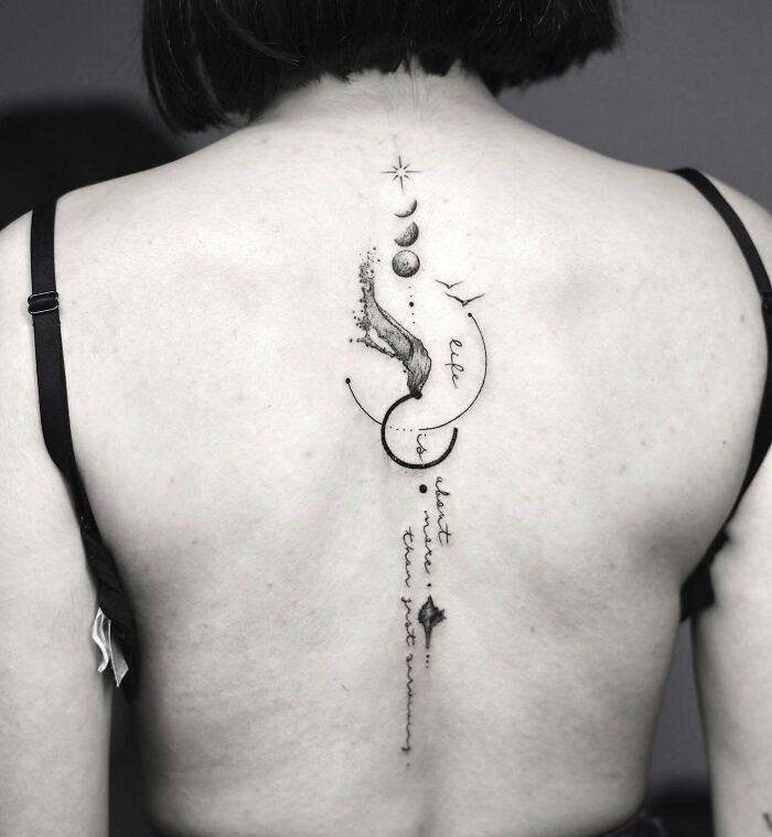 Elegant spine tattoo featuring celestial designs with stars and planets on a woman's back.