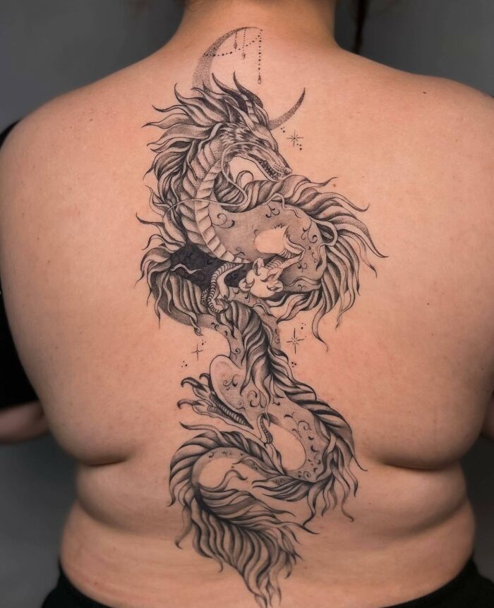 Intricate spine tattoo of a mythical dragon on a person's back.