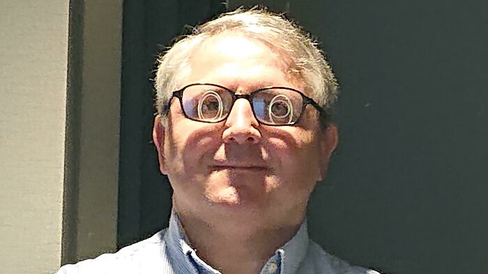 Funny reflections on a man's eyeglasses 