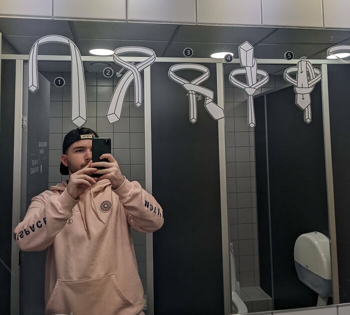 Man taking a picture of a tying a tie instruction 