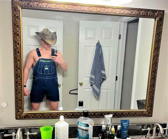 Man in an interesting outfit taking a picture of a mirror 