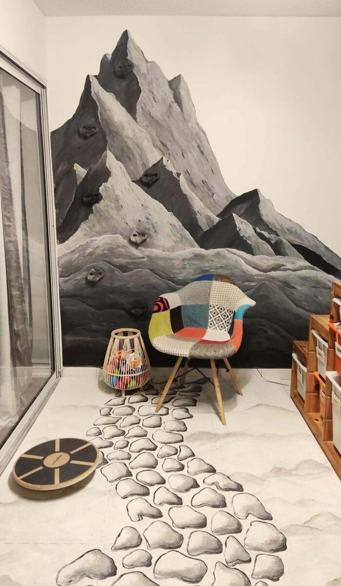 Colorful chair and decorative wall mural with mountain design in a cozy home setting.