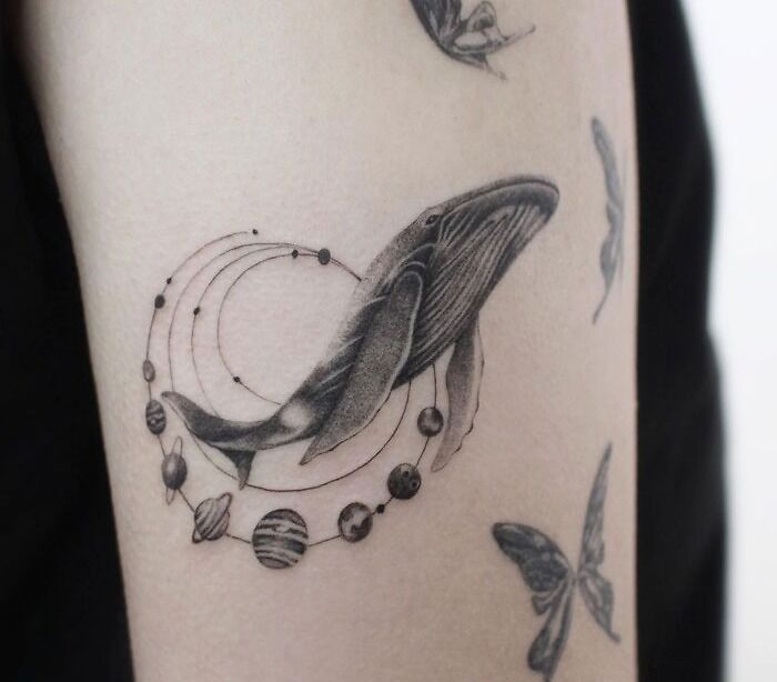 Astrology space tattoo of a whale with planets and orbits, ideal for fans of celestial themes.