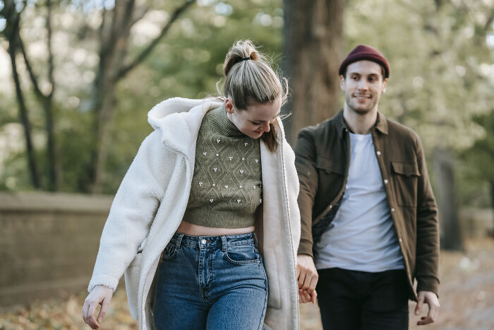 Woman and man holding hands while walking 