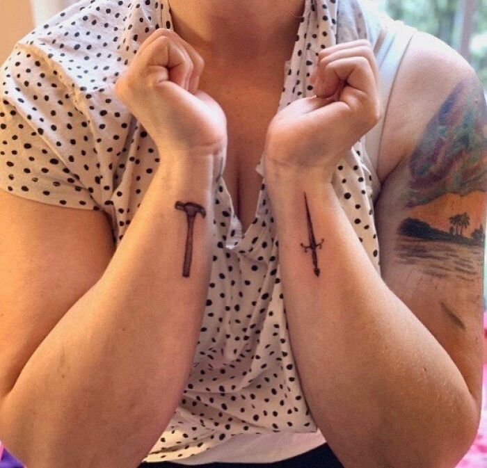 Polka dot blouse with sword and hammer wrist tattoos, highlighting timeless accessory designs.
