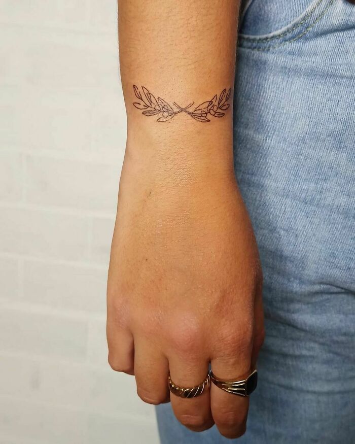 Delicate wrist tattoo with leaf design, making a stylish statement.