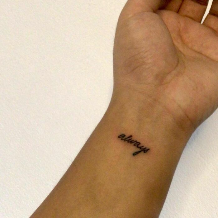 Wrist tattoo with the word "always" in black ink on a person's inner wrist.