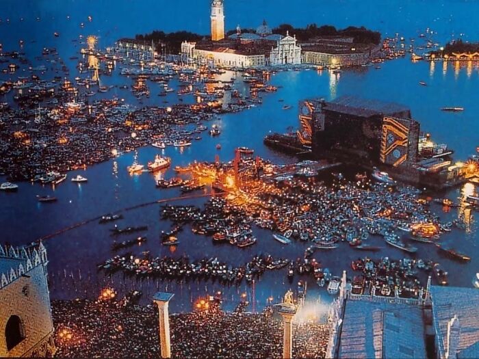 Crowded nighttime harbor scene with thousands of boats and people gathered for an important historical event.