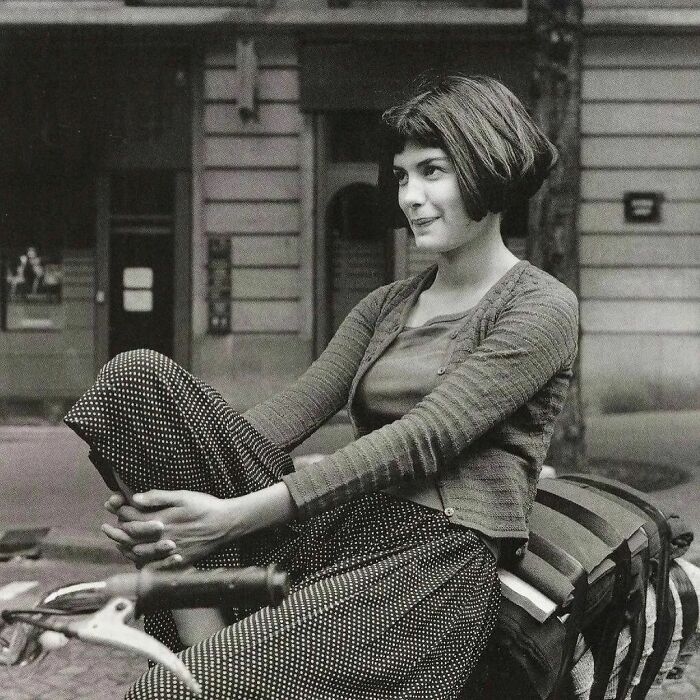 Young woman sitting on a bicycle in a vintage black and white historical photo capturing an important moment.