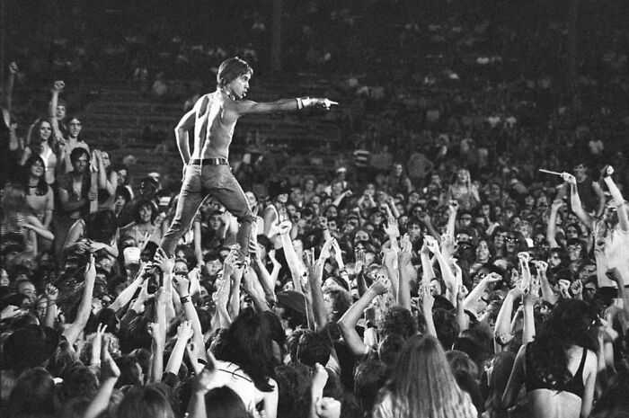 Crowd surfing at a historic concert, capturing a powerful moment in important historical photos showing cultural movements and events.