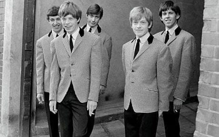 Five young men in matching checkered jackets posing outside, an important historical photo capturing vintage style and camaraderie.