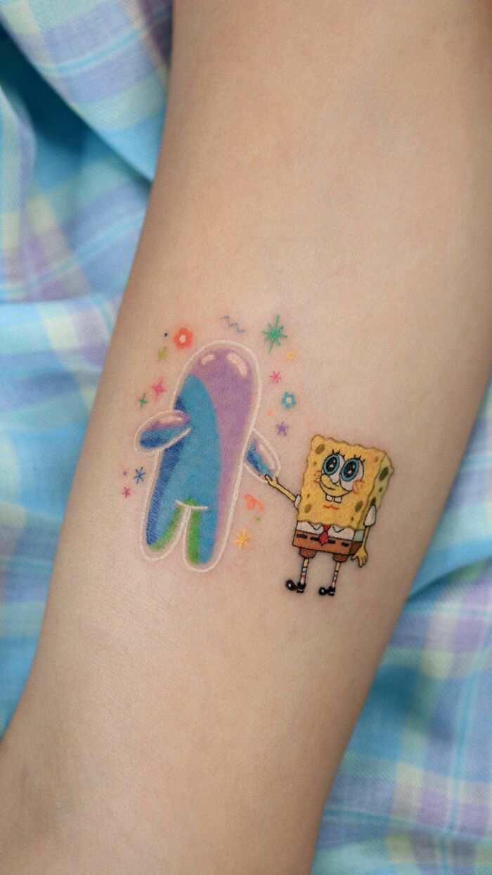 Color tattoo by Saegeem featuring SpongeBob and colorful abstract character on an arm.