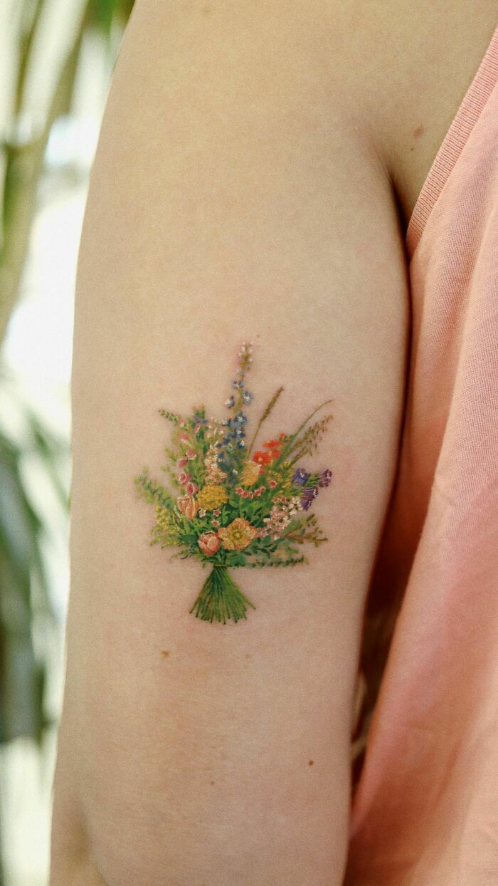 Color tattoo of a floral bouquet on an arm, showcasing detailed artistry by Saegeem.