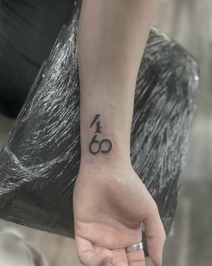 Wrist tattoo design with numbers 4169 on inner forearm.