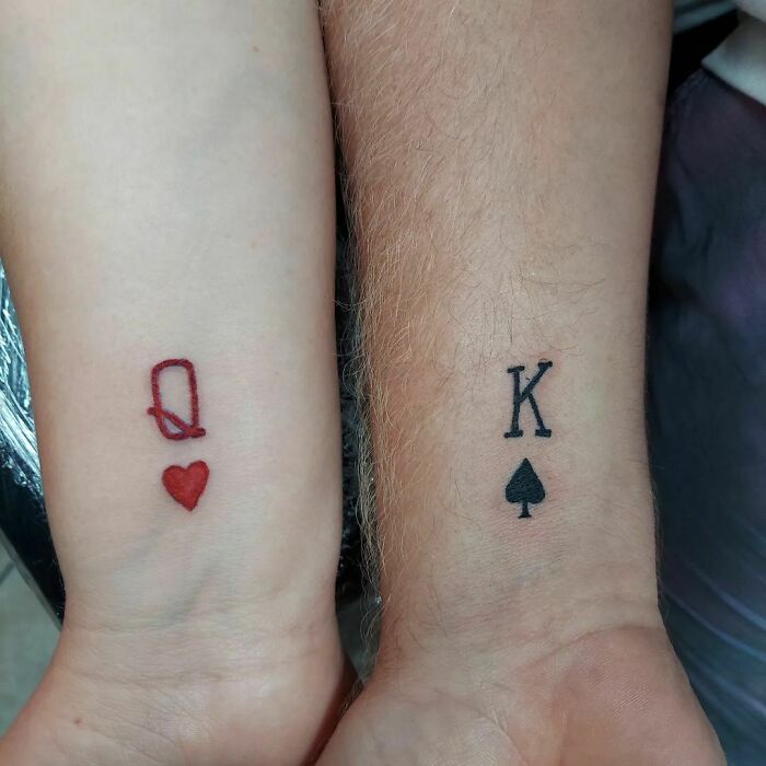 Matching King and Queen card suit wrist tattoos as stylish accessories.