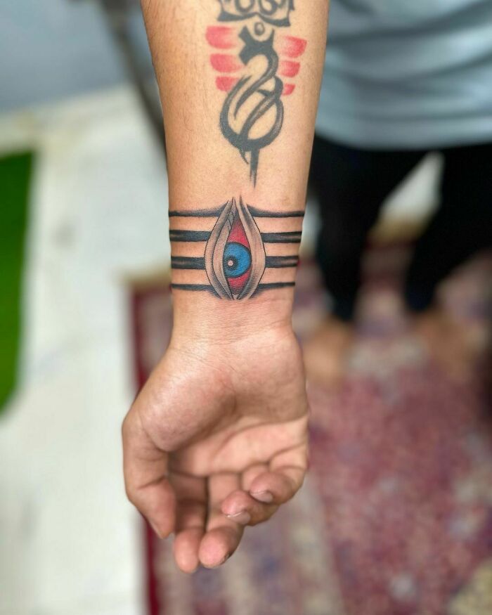 Wrist tattoo with an eye design and abstract elements, showcasing bold statement ink.