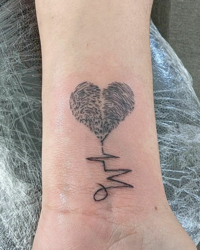 Heart-shaped wrist tattoo with a heartbeat line, a timeless accessory idea.