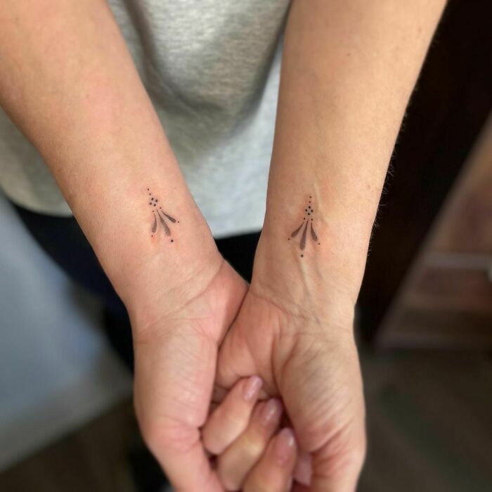 Minimalist wrist tattoos with dot and line design on both wrists, showcasing stylish accessory ideas.