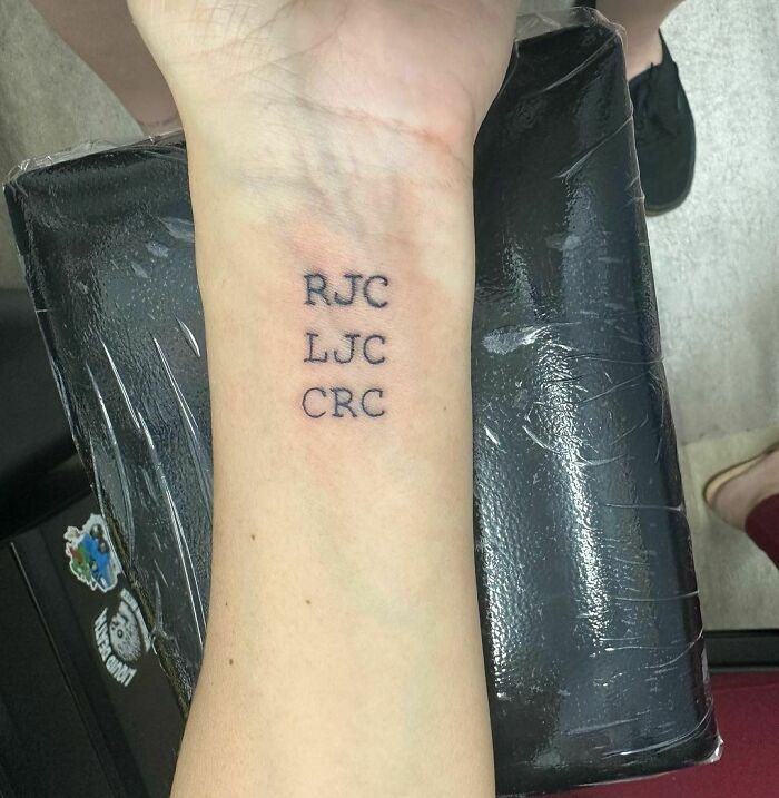Wrist tattoo with initials "RJC, LJC, CRC" on forearm, showcasing a stylish and timeless accessory.